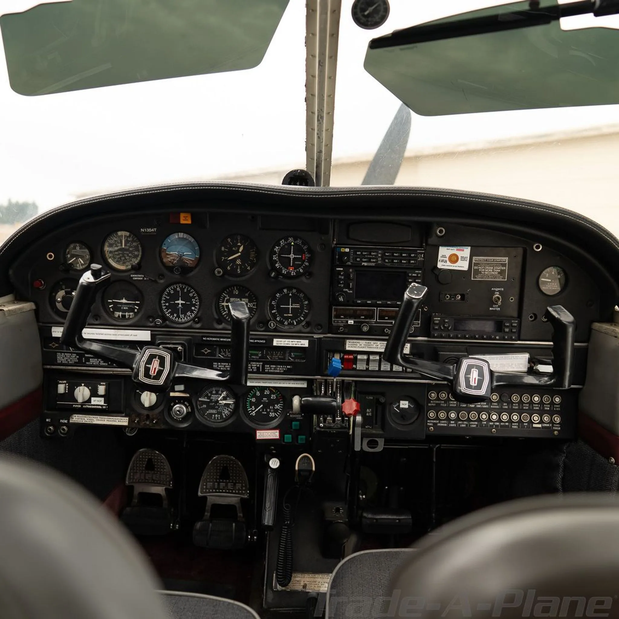 Head-on view of the aircraft's instrument panel with various gauges and controls, showing N1354T.