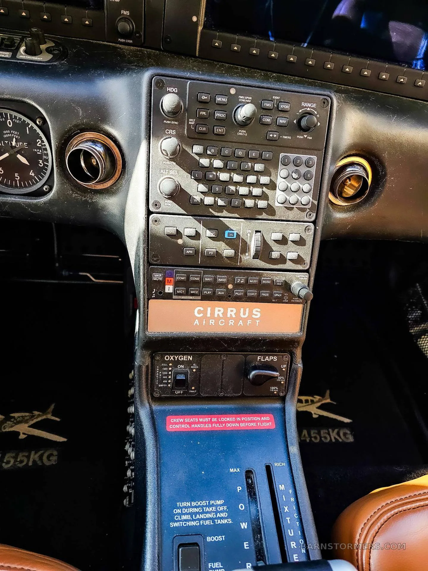A close-up view of the center console and avionics stack in a Cirrus aircraft cockpit, showing the throttle and oxygen controls.