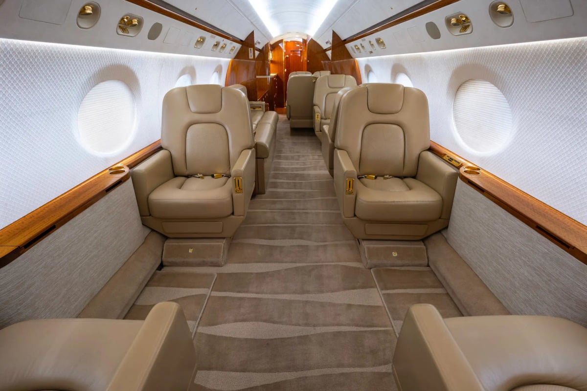 Gulfstream G450 cabin interior with beige leather seats and carpet.