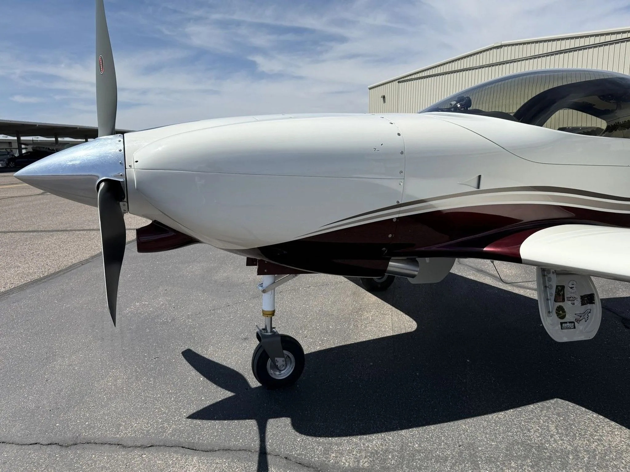 A close-up view of the propeller and nose of the white and maroon aircraft (N49LJ).