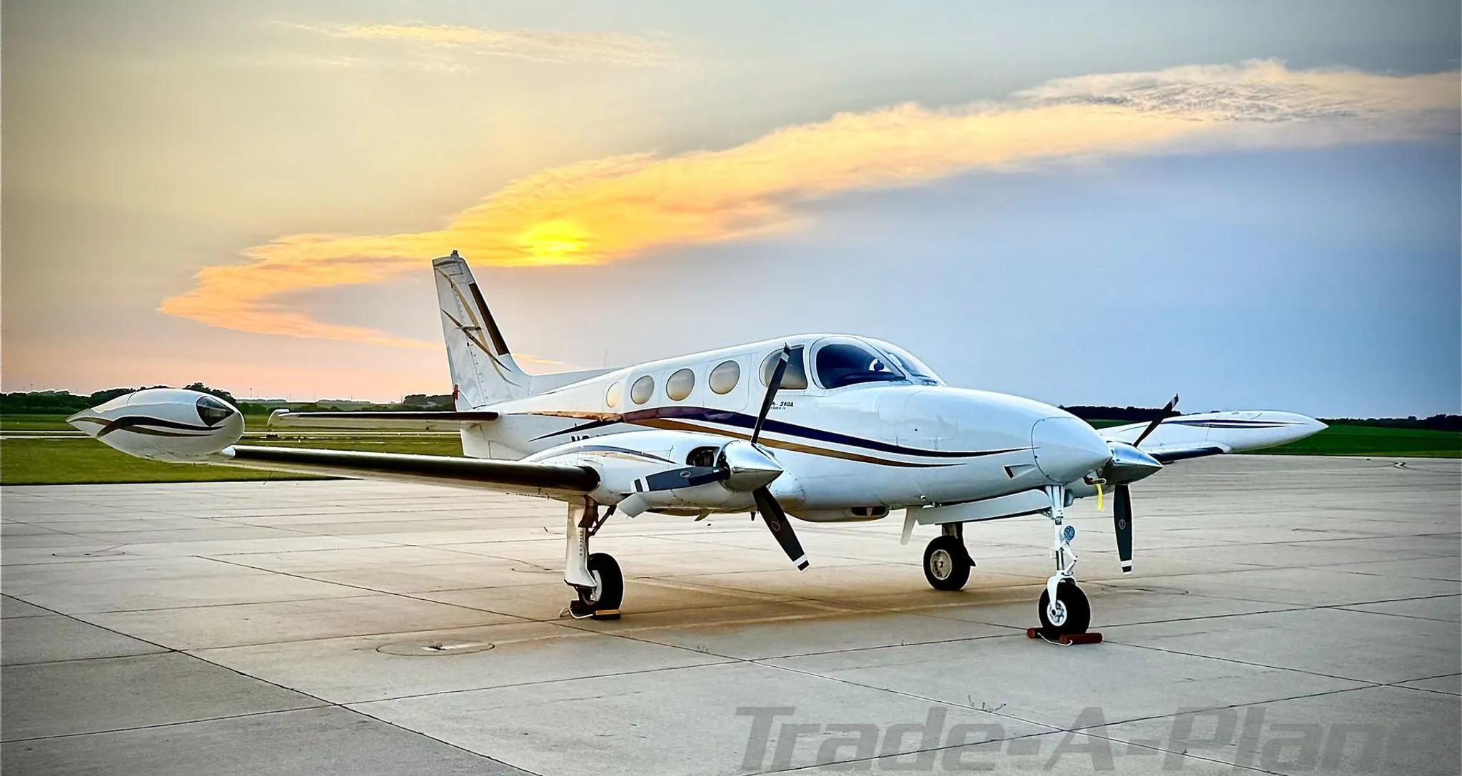 A Cessna 340A parked on the tarmac during sunset.