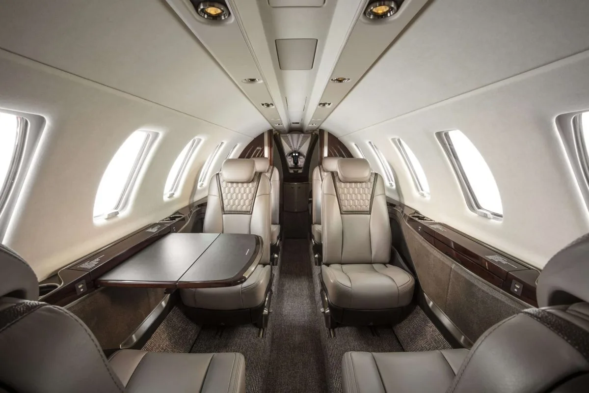 A view of the aircraft's interior cabin with leather seats and a table.