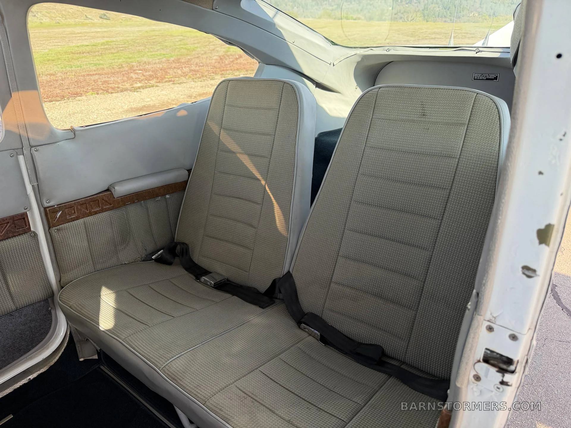The rear cabin seats of a Cessna aircraft, upholstered in a light patterned fabric.