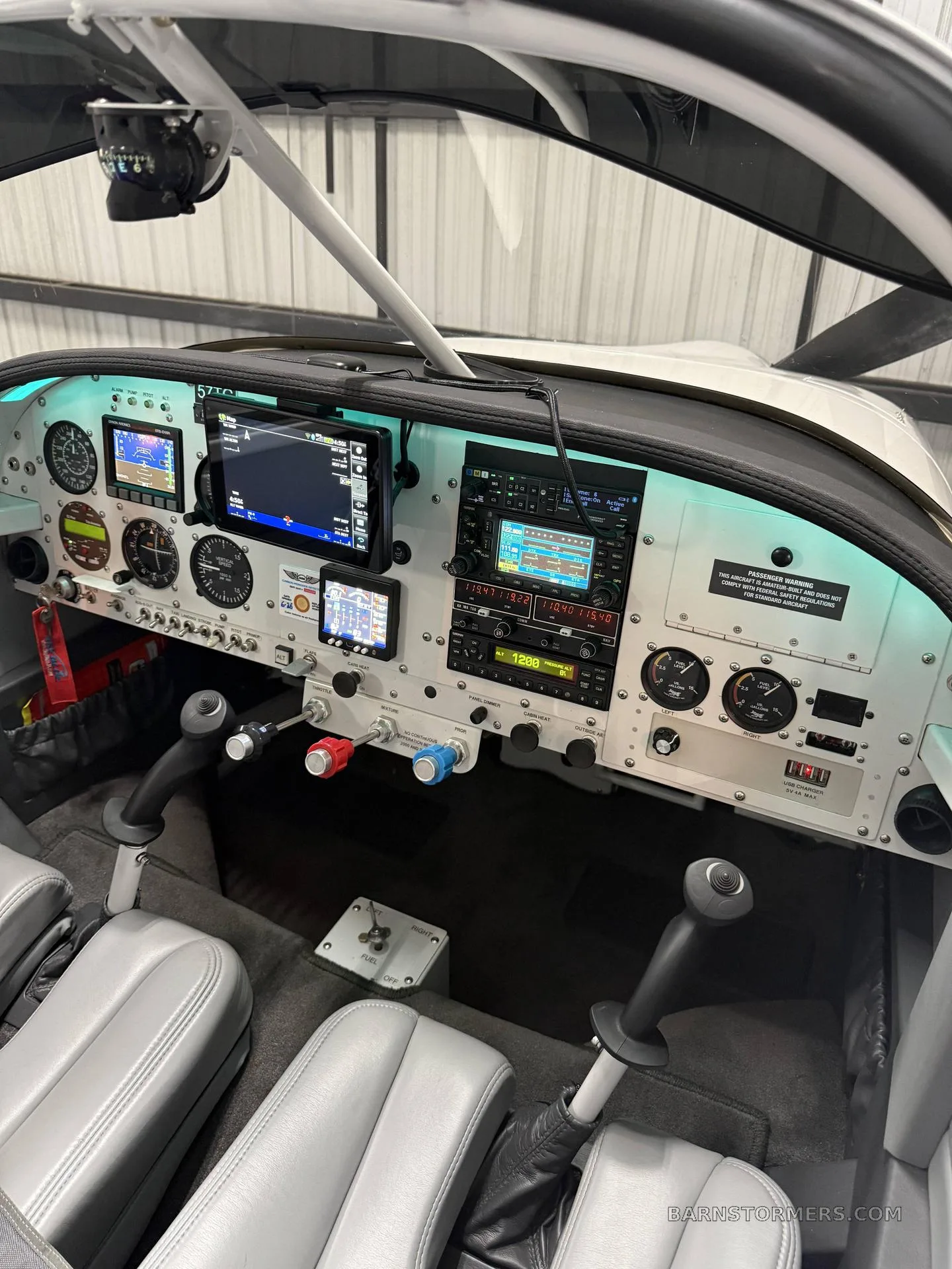 The cockpit of a Vans RV-7 aircraft showing the instrument panel with multiple screens and controls.