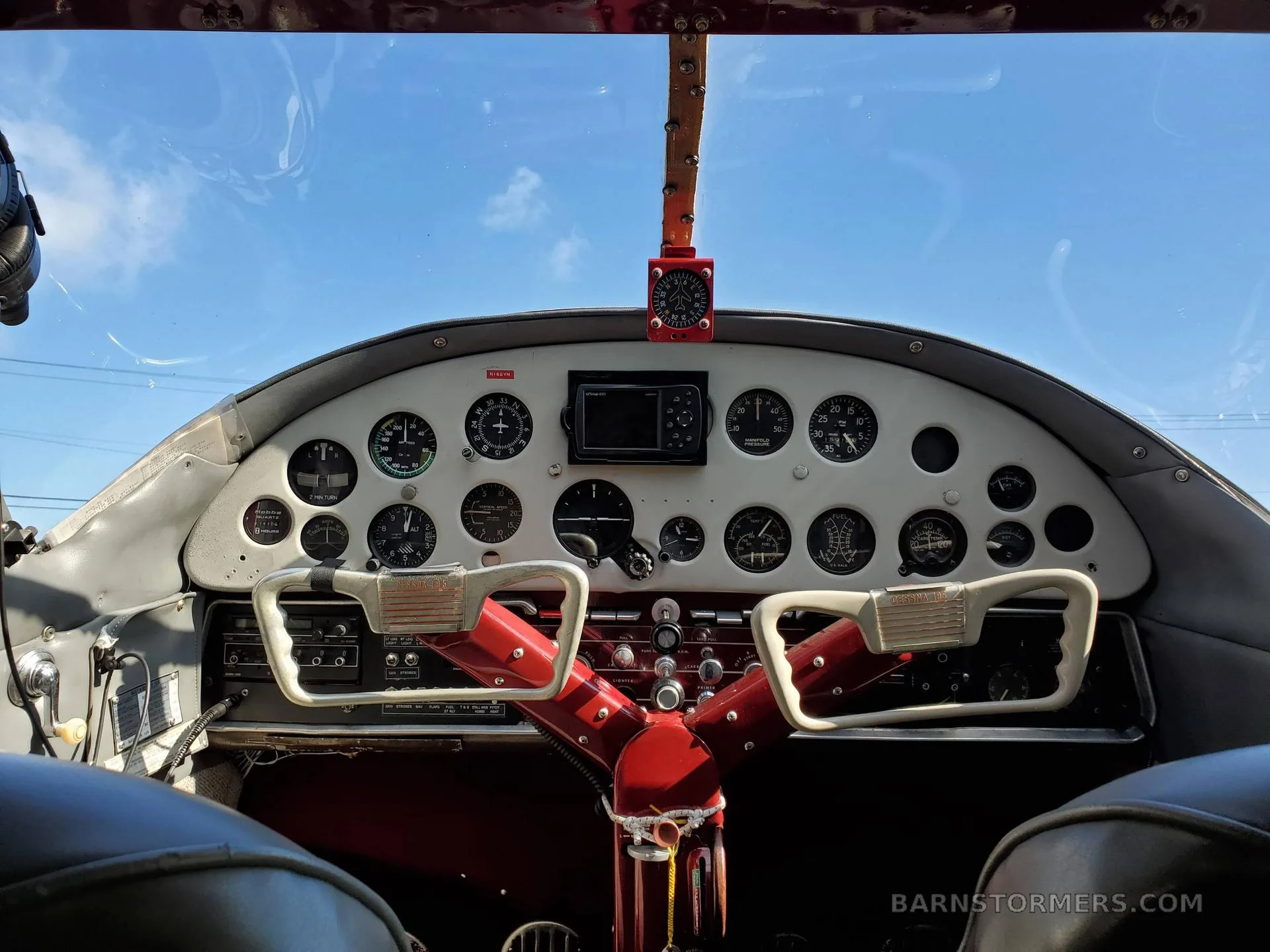 The cockpit of a vintage aircraft, showing the instrument panel with various gauges and two control yokes.