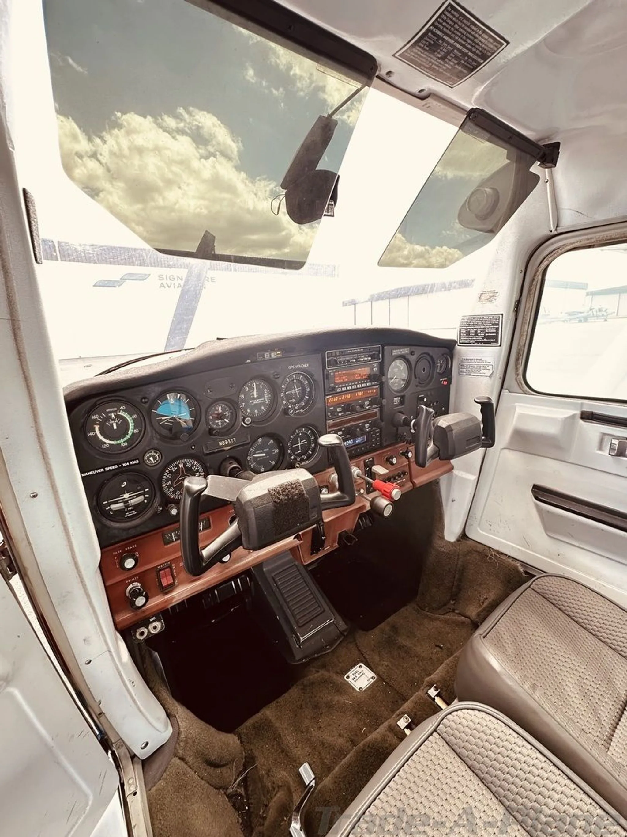 The cockpit of a Cessna 172, showing the instrument panel with N89377 visible, yokes, and front seats.