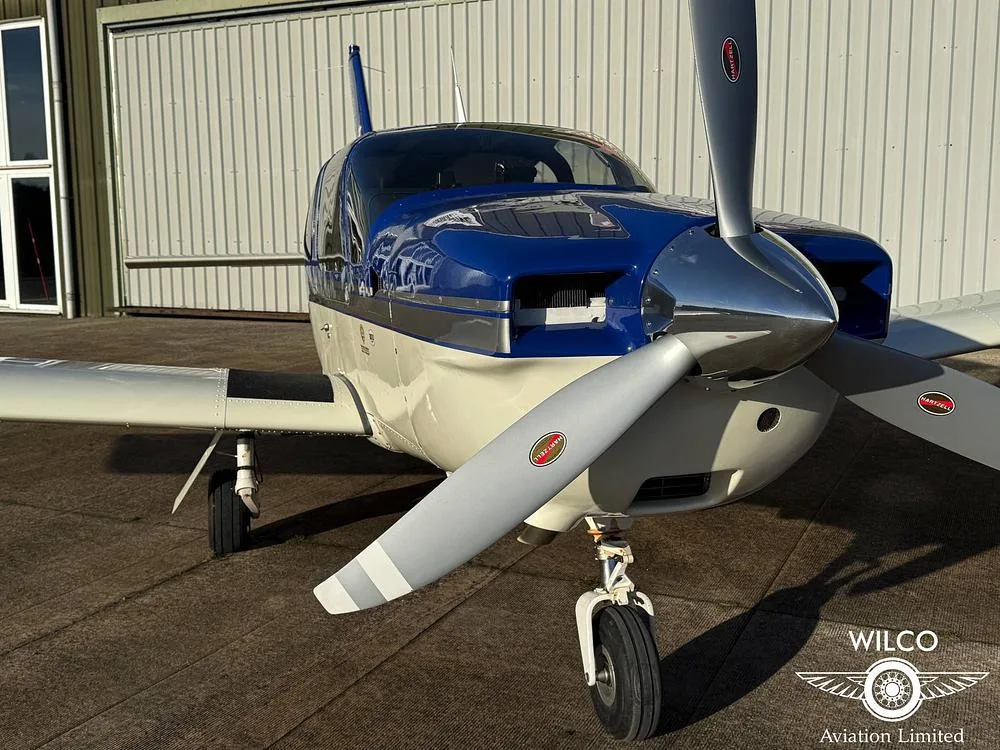A close-up front view of the blue and white single-engine aircraft, N5ZY, showing its propeller and nose.