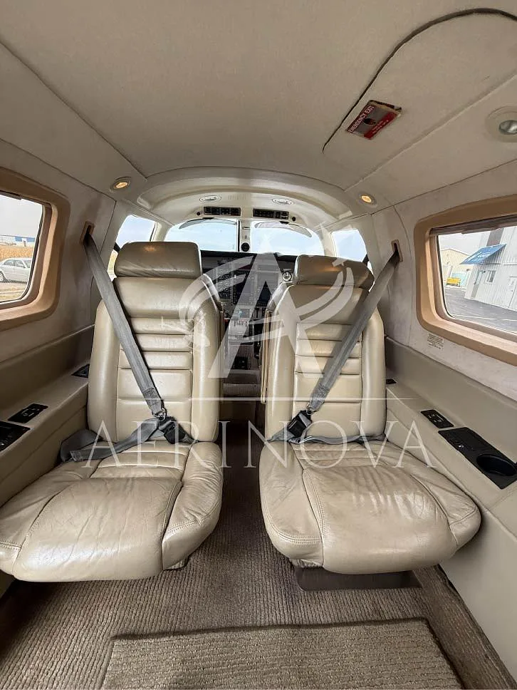 The light tan leather passenger seats in the cabin of the Piper Malibu Mirage N92821, looking towards the cockpit.