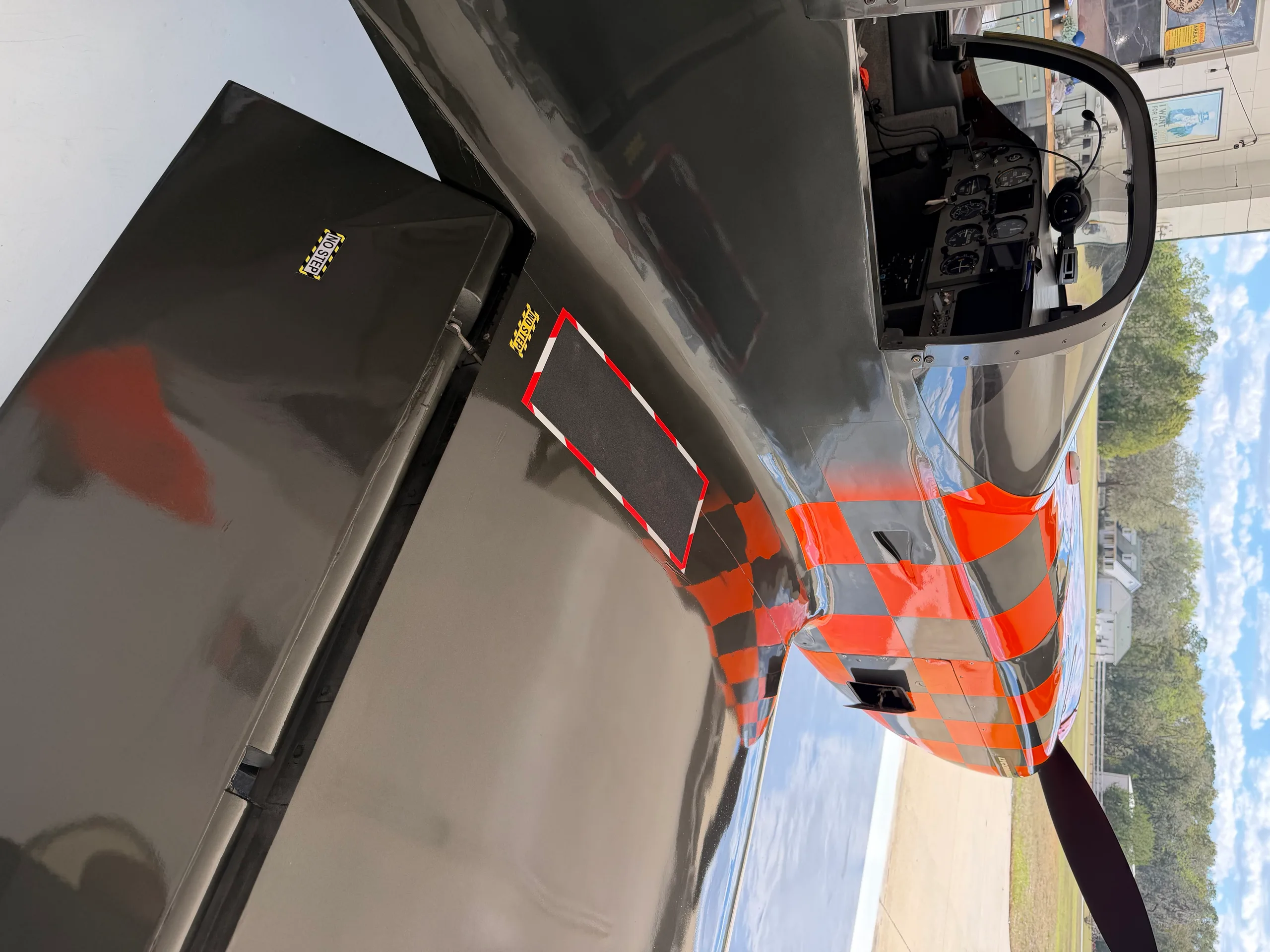 A close-up side view of the black and orange checkered experimental aircraft, N7224A, showing the wing and cockpit.