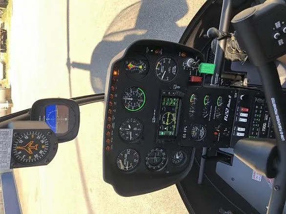 The instrument panel and controls of a Robinson R22 helicopter cockpit.
