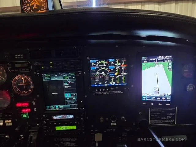 A close-up view of the aircraft's instrument panel, showing multiple illuminated digital displays and traditional gauges.
