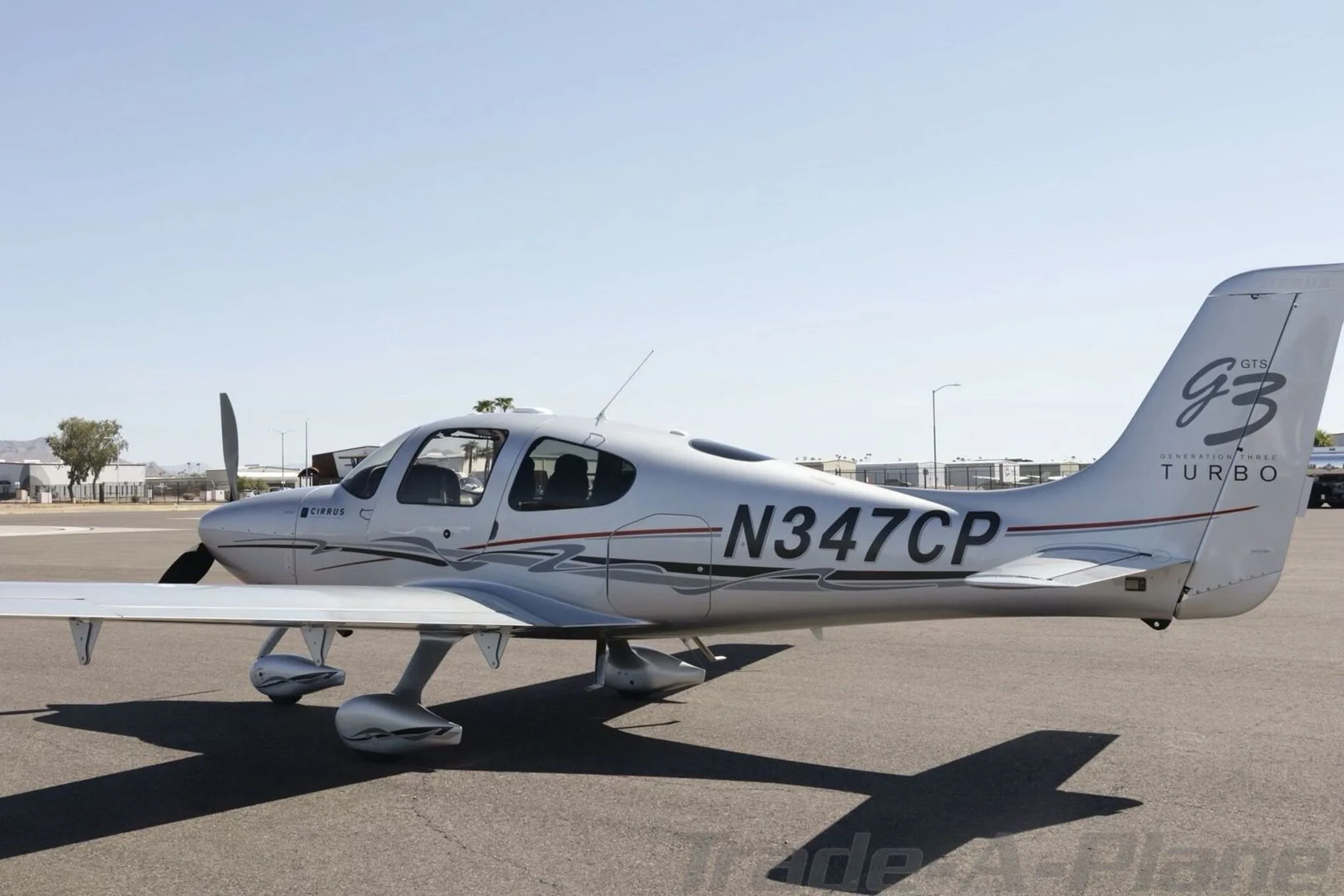 A rear three-quarter view of the silver Cirrus SR22 GTS Generation Three Turbo aircraft, registration N347CP, on an airport tarmac.