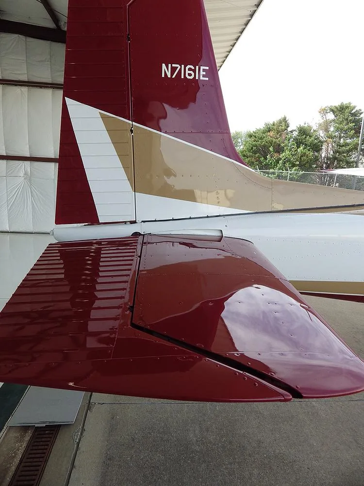 A close-up view of the red and gold tail section of aircraft N7161E, showing the horizontal stabilizer.