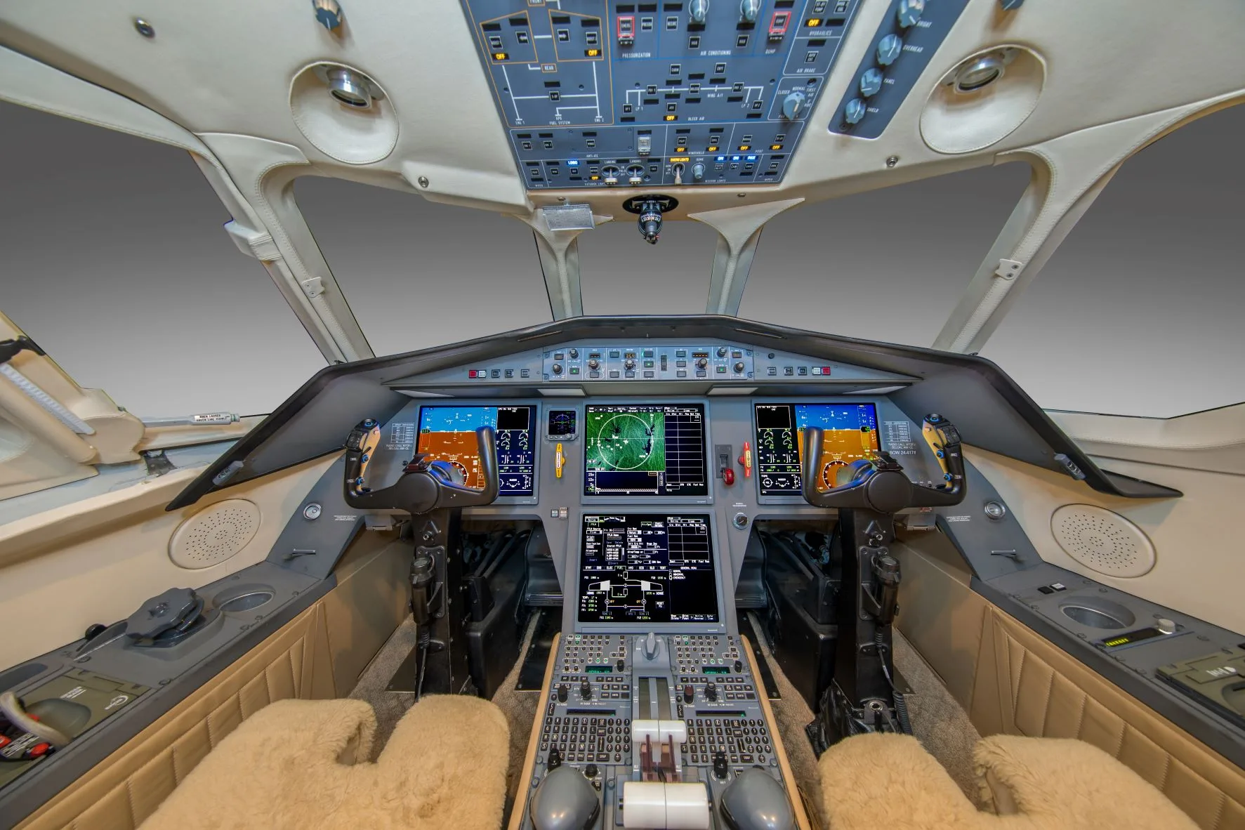 A modern aircraft cockpit with multiple digital displays and control yokes.