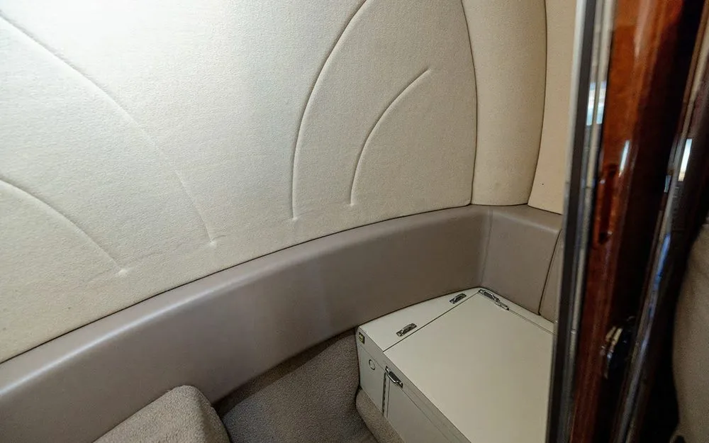 A close-up view of the beige side paneling and a small storage compartment in the aircraft's cabin.