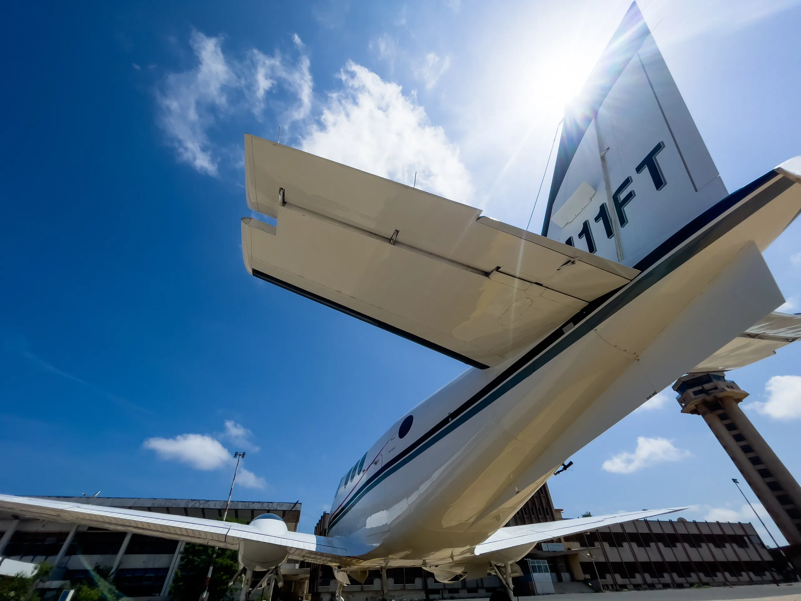 The tail of a King Air N411FT is shown with the control tower in the background.