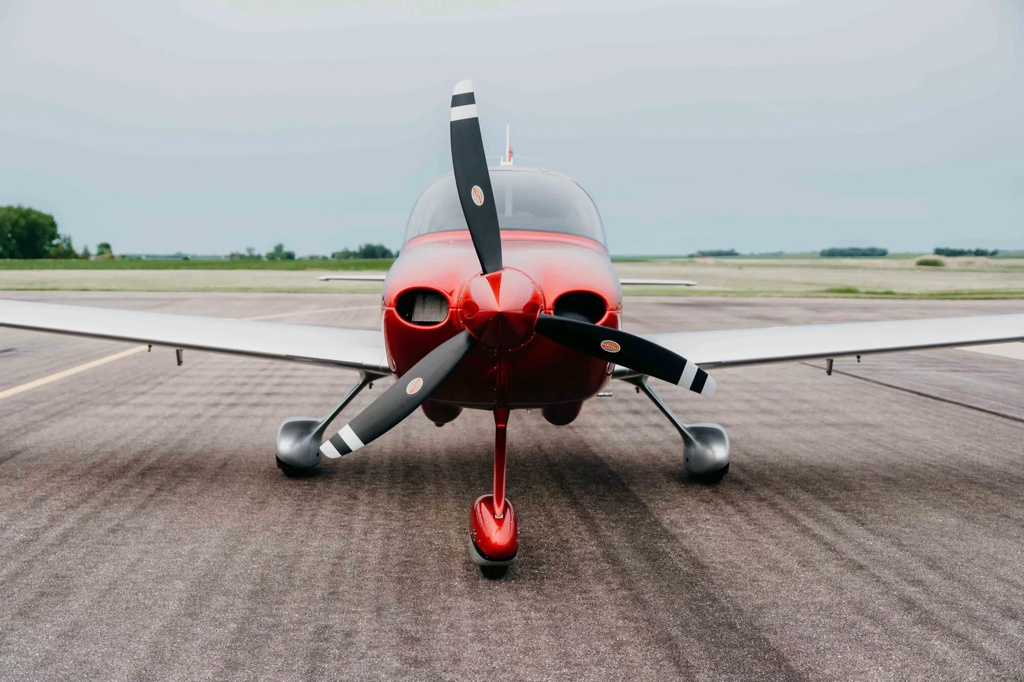 A head-on view of the red and silver Cirrus SR20 Premium aircraft (N11PS) on the tarmac.