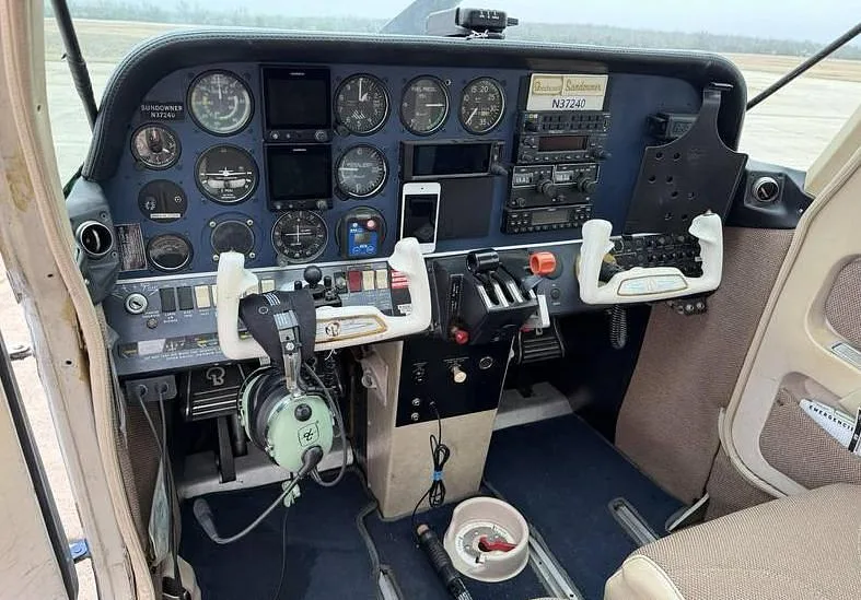 The cockpit of a Beechcraft Sundowner N37240, showing the instrument panel, yokes, and controls.