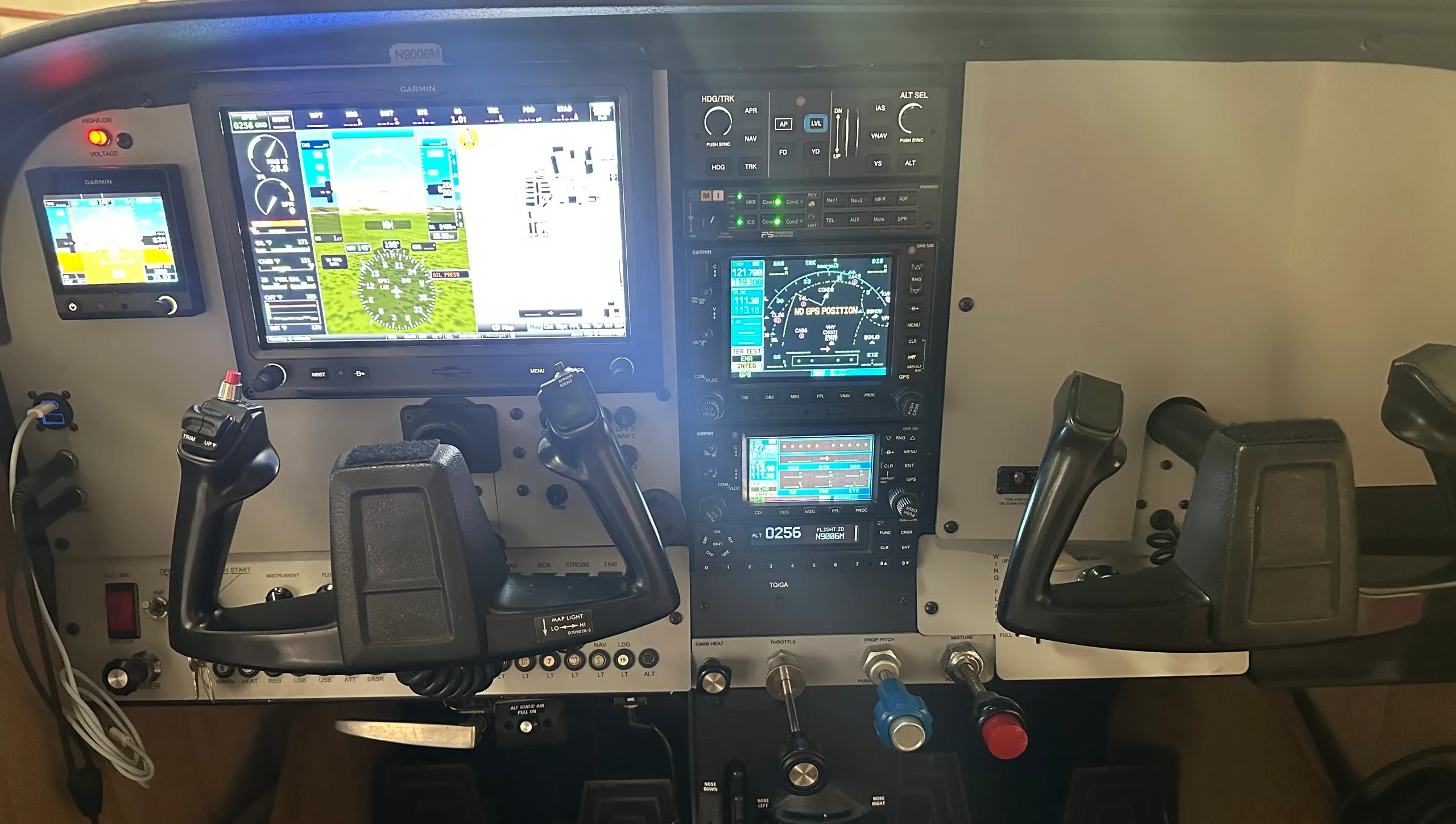 The modern glass cockpit of the Cessna 182, featuring multiple digital displays and control yokes.