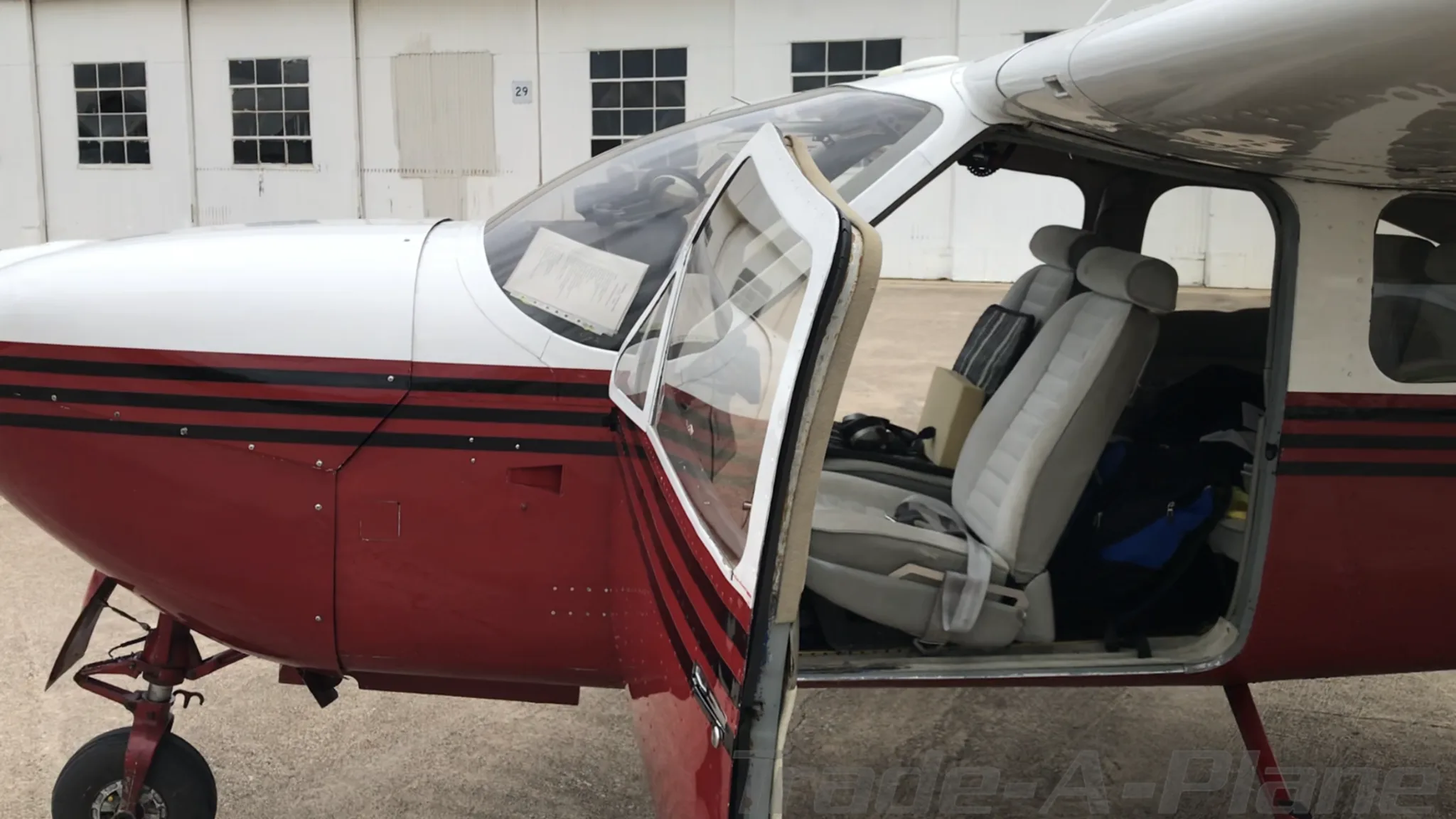 A close-up view of the open door and light gray interior seats of the N33297 aircraft.
