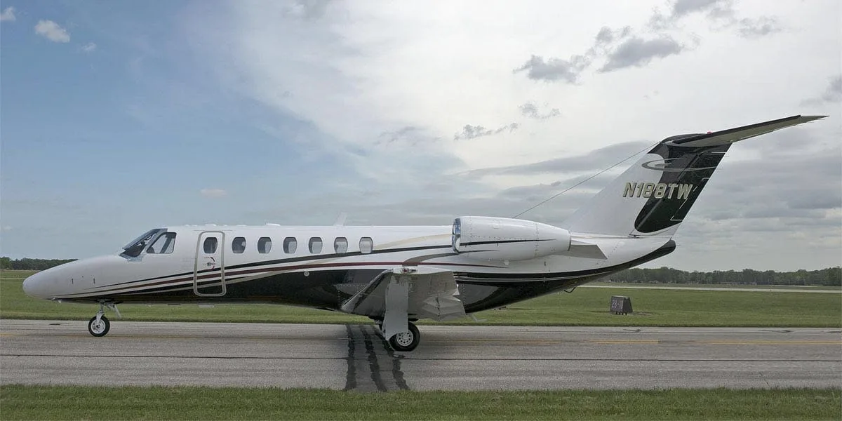 A white and black business jet with registration N188TW on the tail, parked on a tarmac under a cloudy sky.