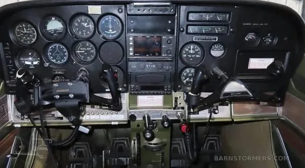 The full instrument panel of a Cessna 172, showing gauges, radios, and control yokes.
