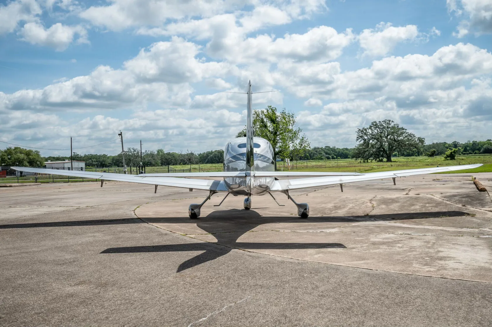 A rear view of the silver and black Cirrus SR22T GTS Platinum aircraft N219TW on an airfield.