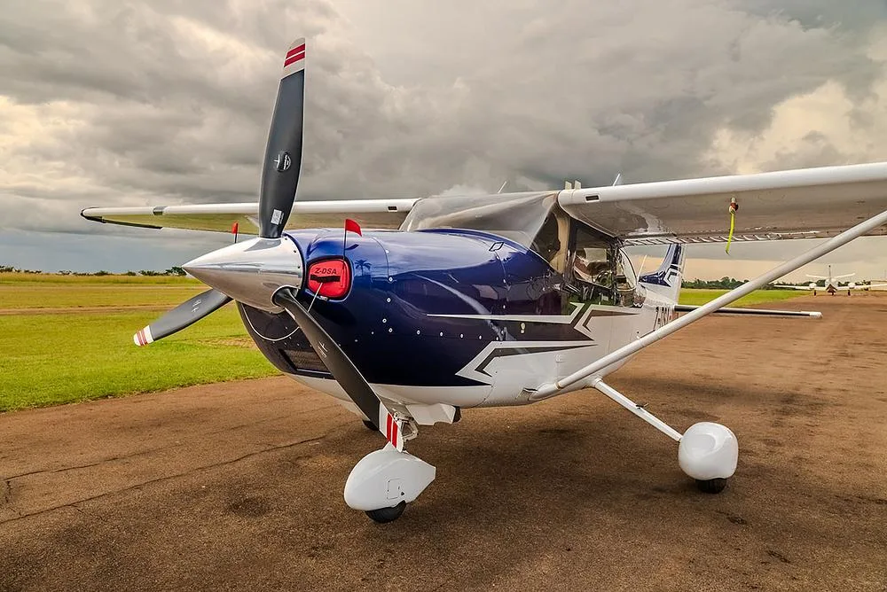 A close-up front-quarter view of a blue and white Cessna Skylane (Z-DSA) on a tarmac.