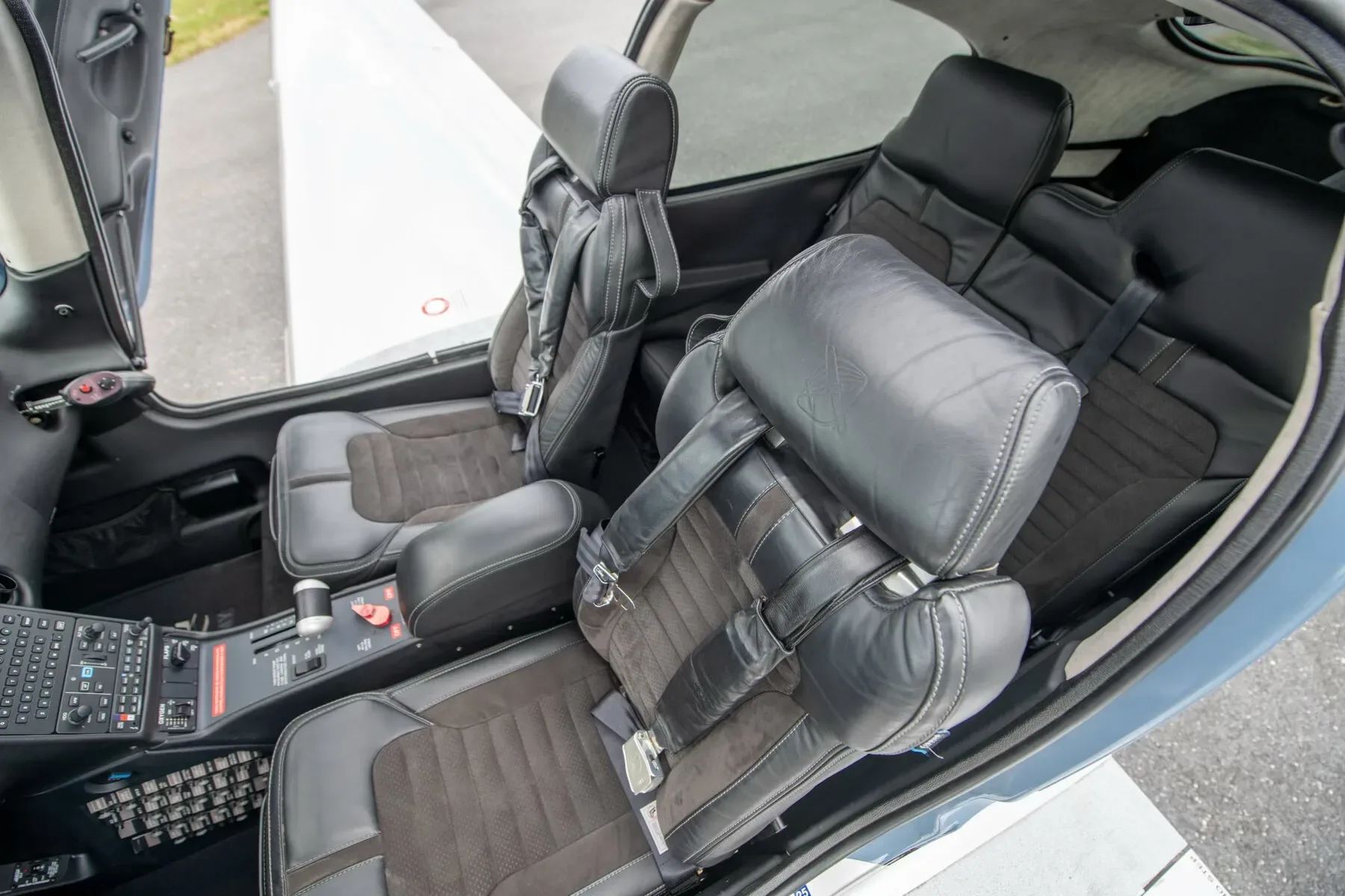 View of the black leather and suede front and rear seats inside the aircraft cabin.