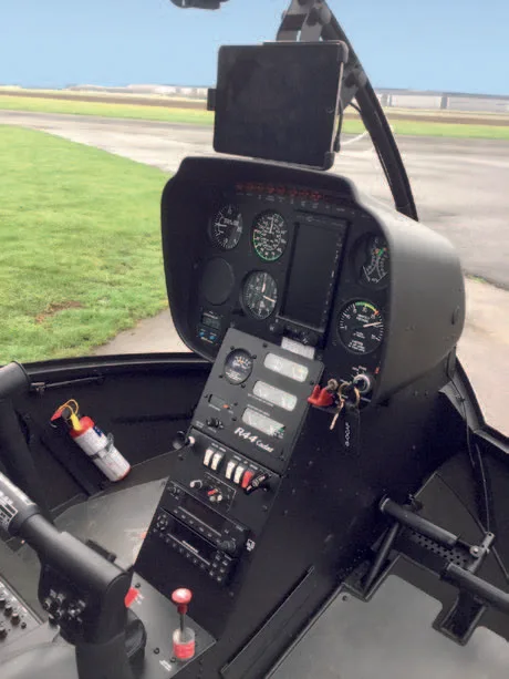 The instrument panel and controls of a Robinson R44 Cadet helicopter, with a tablet mounted above.
