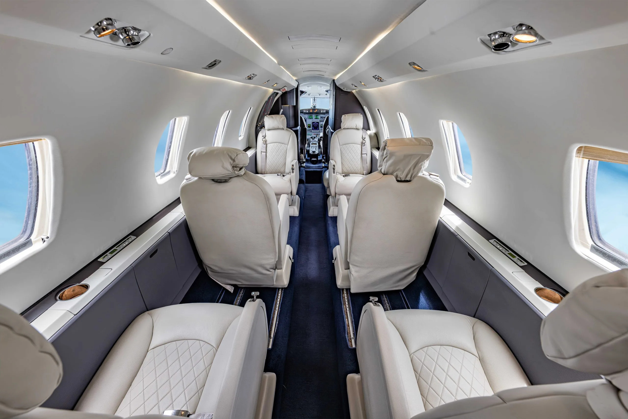 Forward view of the aircraft's interior with white leather seats.