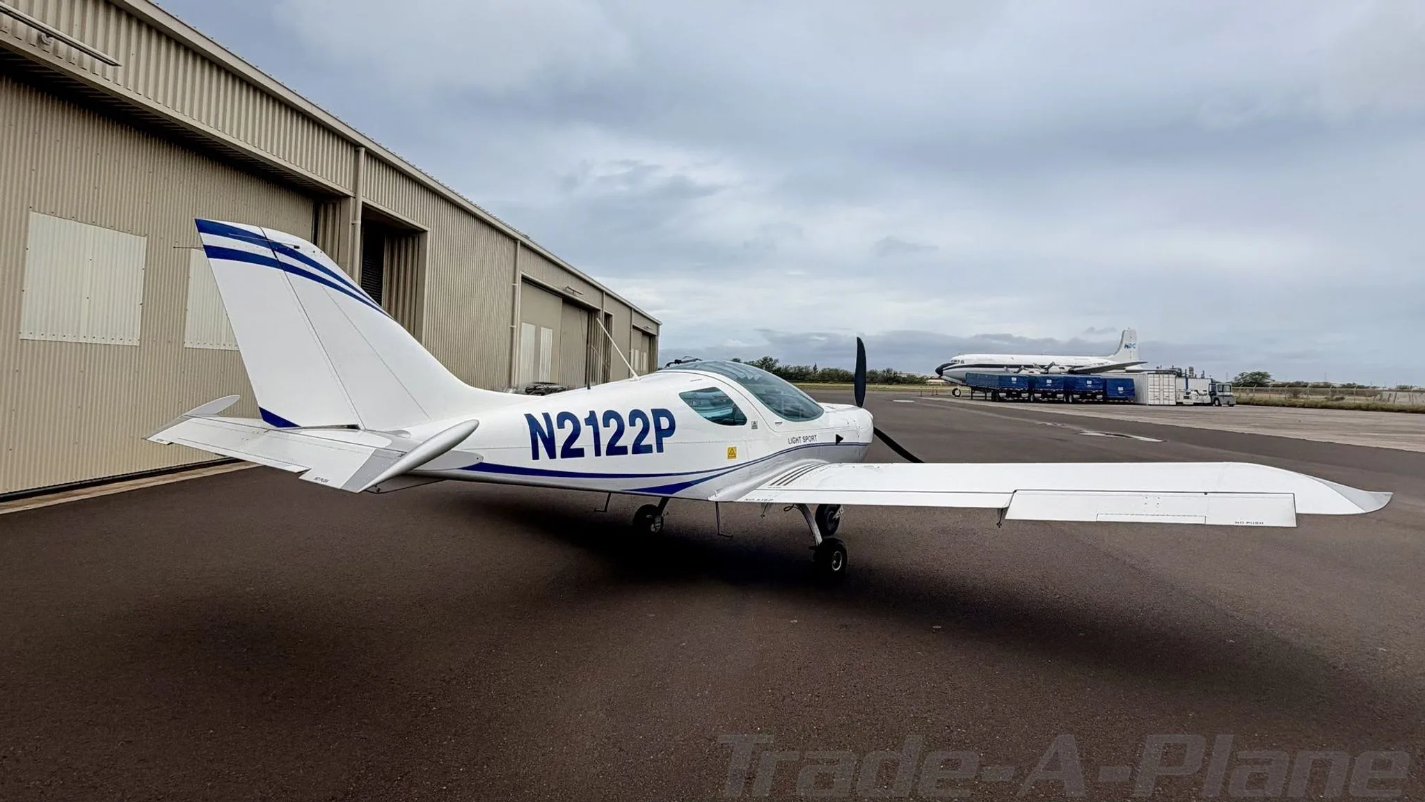 The aircraft positioned near a hangar.