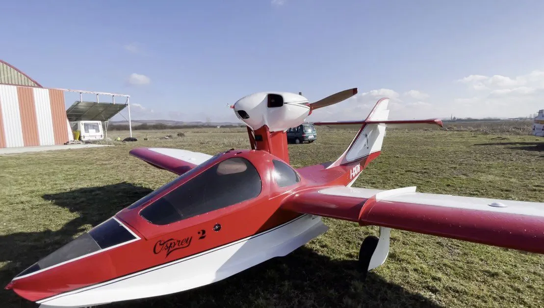 Osprey 2 aircraft with red and white paint scheme on the ground.