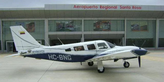 A white and blue single-engine propeller aircraft, registration HC-BNG, is parked on the tarmac in front of Aeropuerto Regional Santa Rosa.