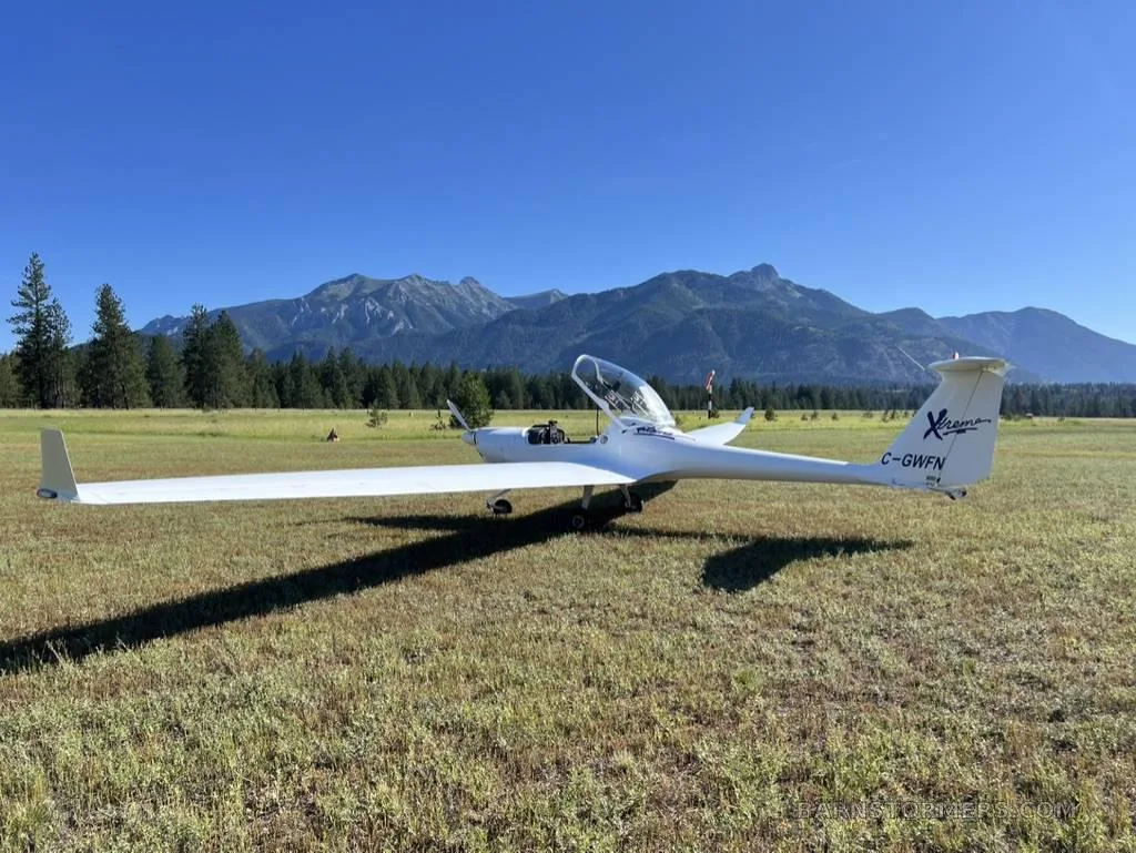 The cockpit of a glider, featuring analog instruments, a smartphone-based GPS display, and flight controls.
