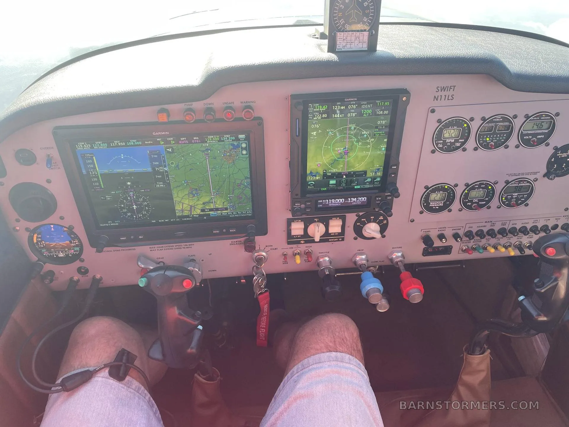 A pilot's view of a modern aircraft cockpit with two large Garmin displays, traditional gauges, and controls.