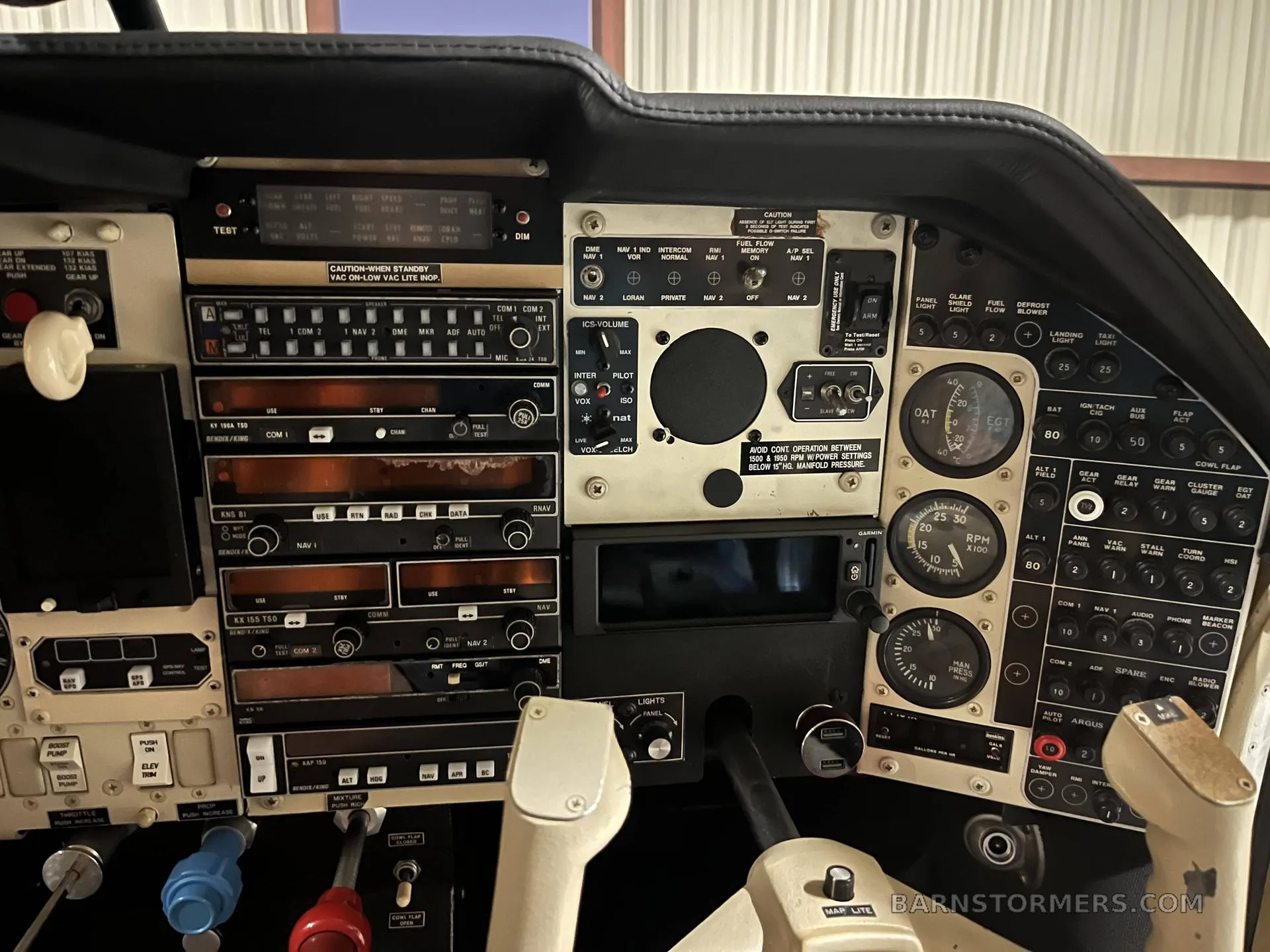 A wide view of an aircraft cockpit instrument panel, showing controls, gauges, and avionics.