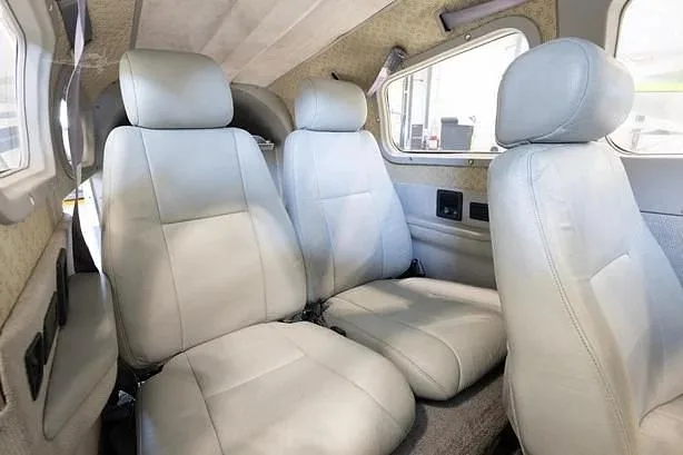 The light grey leather rear cabin seats of a small aircraft.