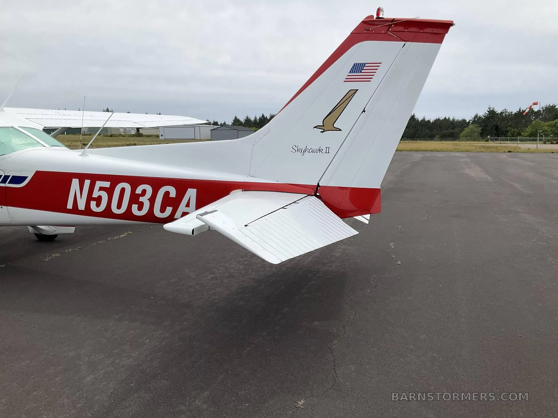 A close-up of the tail of a white and red Cessna 172 Skyhawk II (N503CA) showing the N-number and tail art.