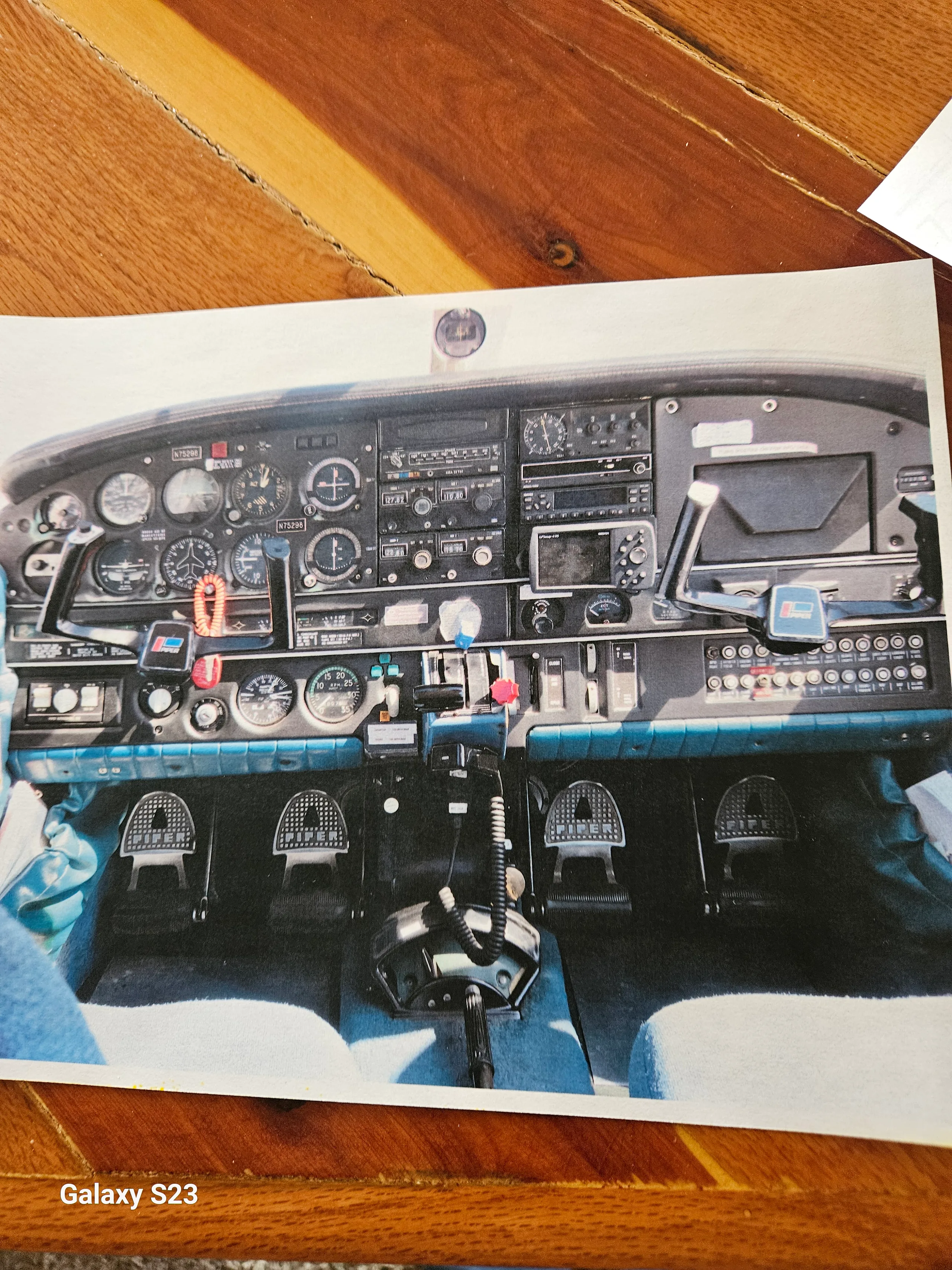 The cockpit of an aircraft, showing the instrument panel with various gauges, avionics, and flight controls.