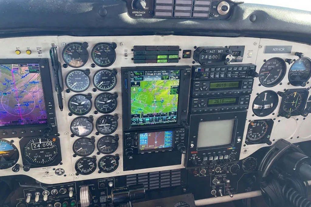 The detailed instrument panel of a Beechcraft King Air cockpit, featuring multiple analog gauges and modern digital displays.