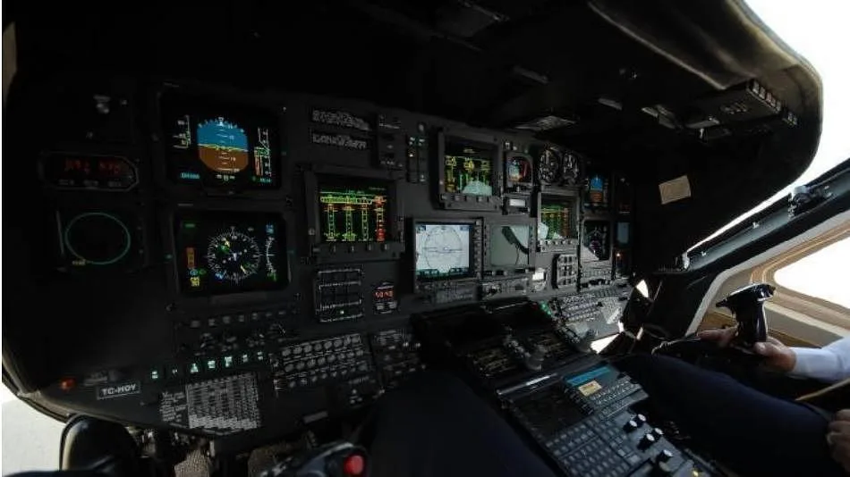The cockpit of a helicopter with multiple digital displays and controls.