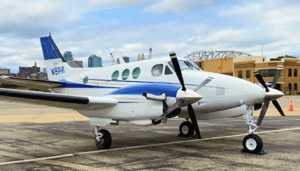 Beechcraft King Air with white and blue paint scheme on the tarmac.