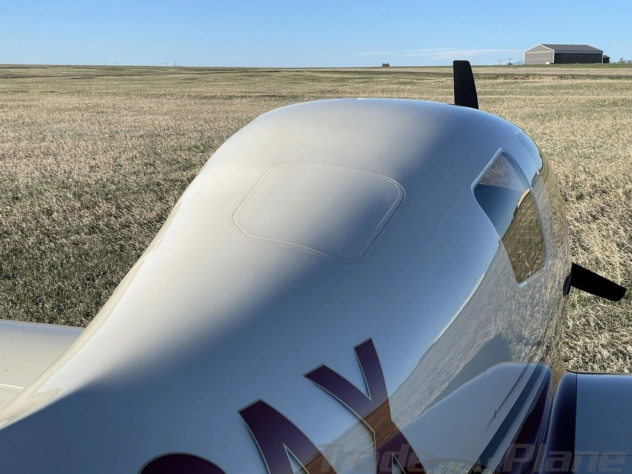 An overhead view of the white fuselage of aircraft N23AX, showing the top of the cabin and part of the tail.