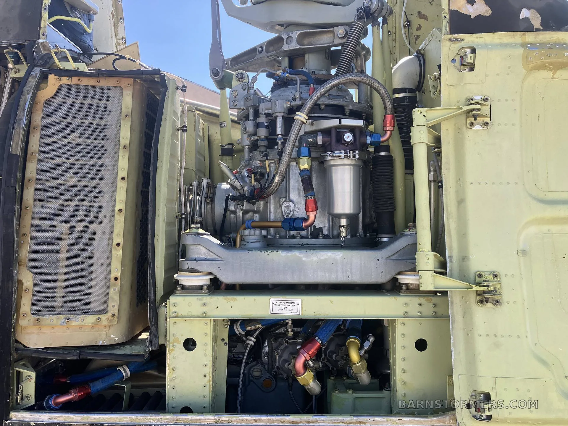 A close-up view of the complex engine and hydraulic systems inside a military helicopter's bay.
