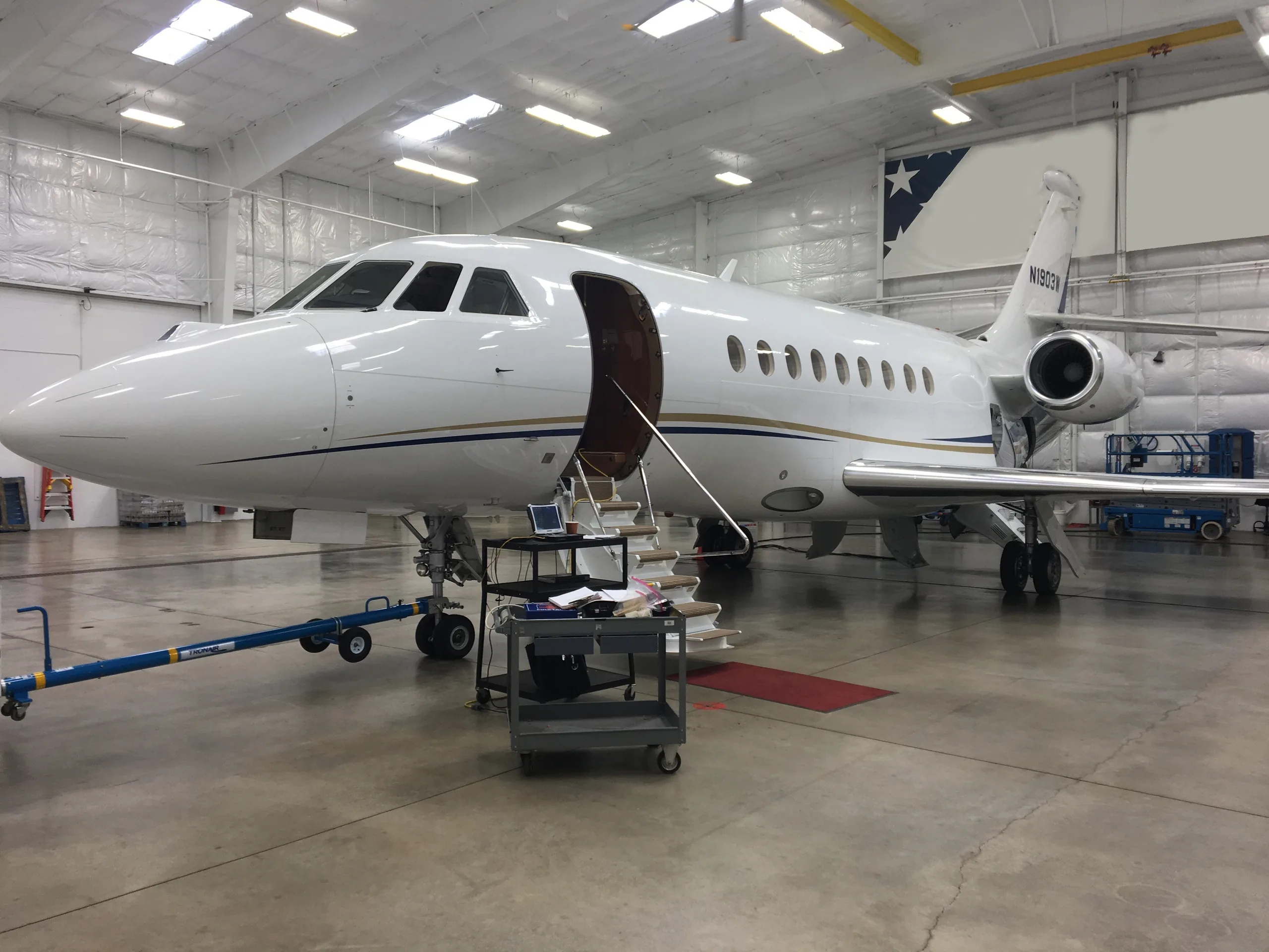 Falcon 2000EX EASy in a hangar with the door open.