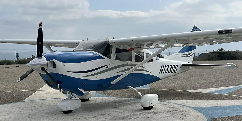 Front-left view of a white and blue Cessna Stationair TC (N1330G) parked on an airfield.