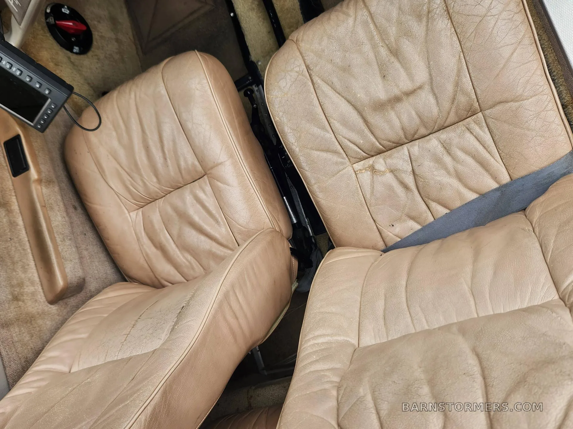 Overhead view of the tan leather seats in the aircraft cabin.