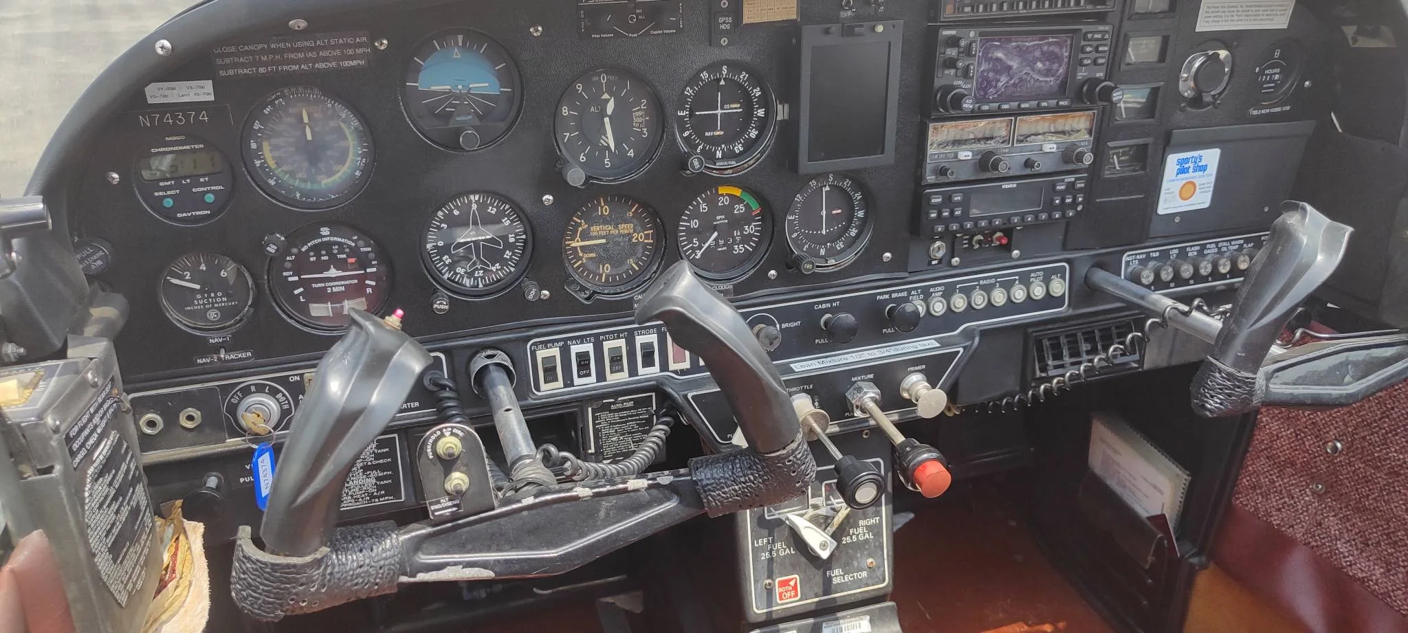 Close-up view of the instrument panel and controls of the N74374 aircraft, showing various gauges and switches.