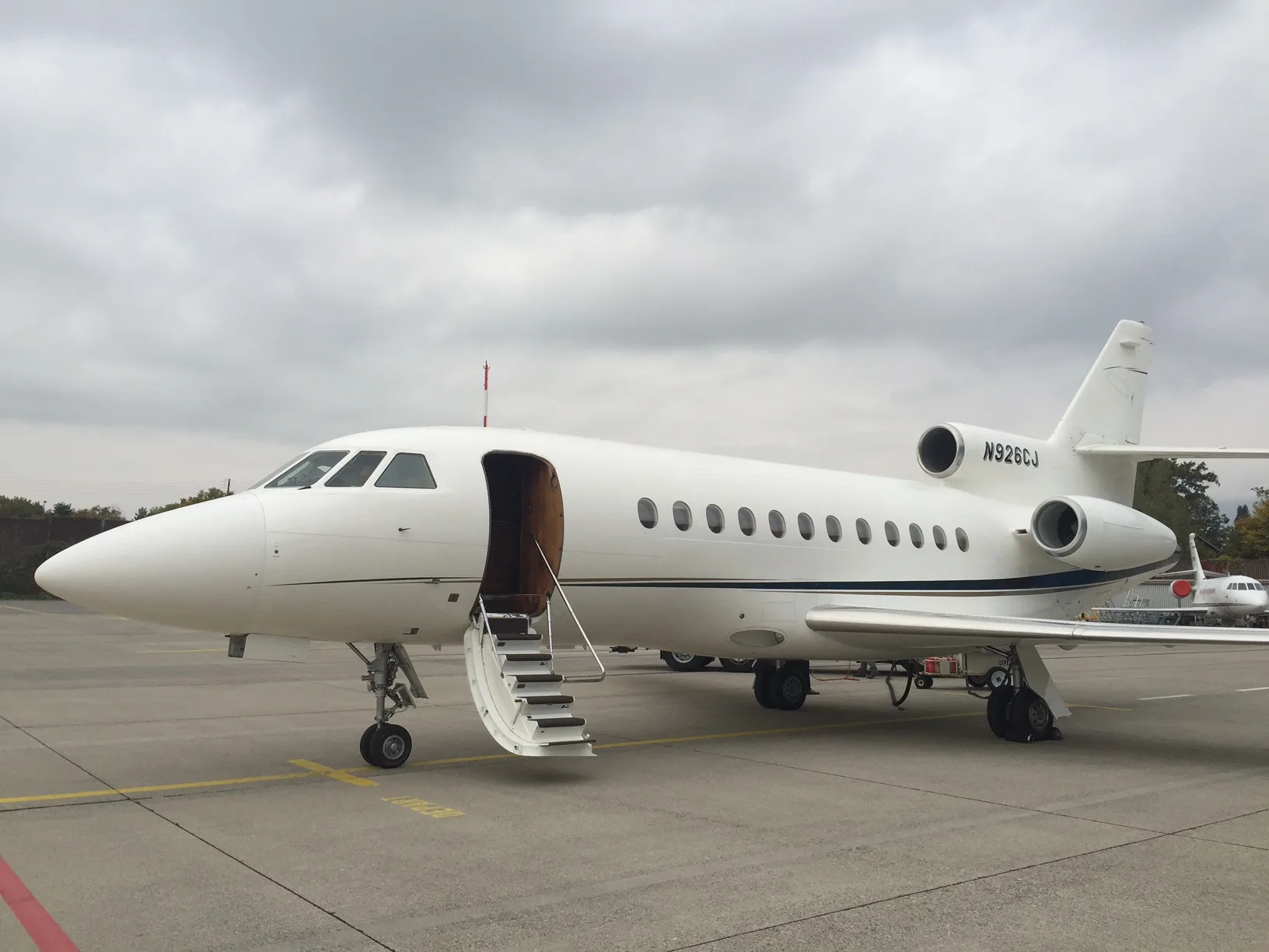 Side view of the white aircraft with the door open and stairs extended.